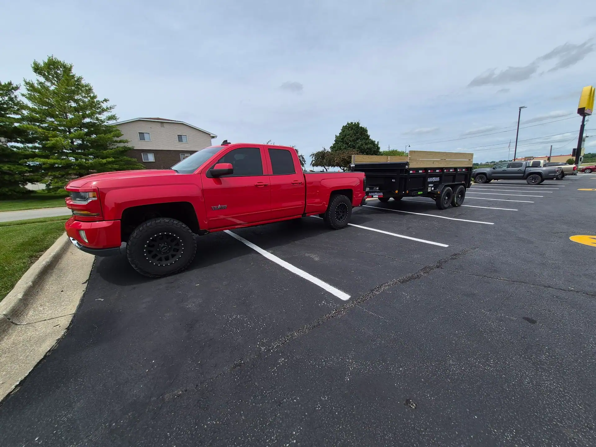 Red pickup truck and black dump trailer used by B&B Hauling for junk removal in Des Moines