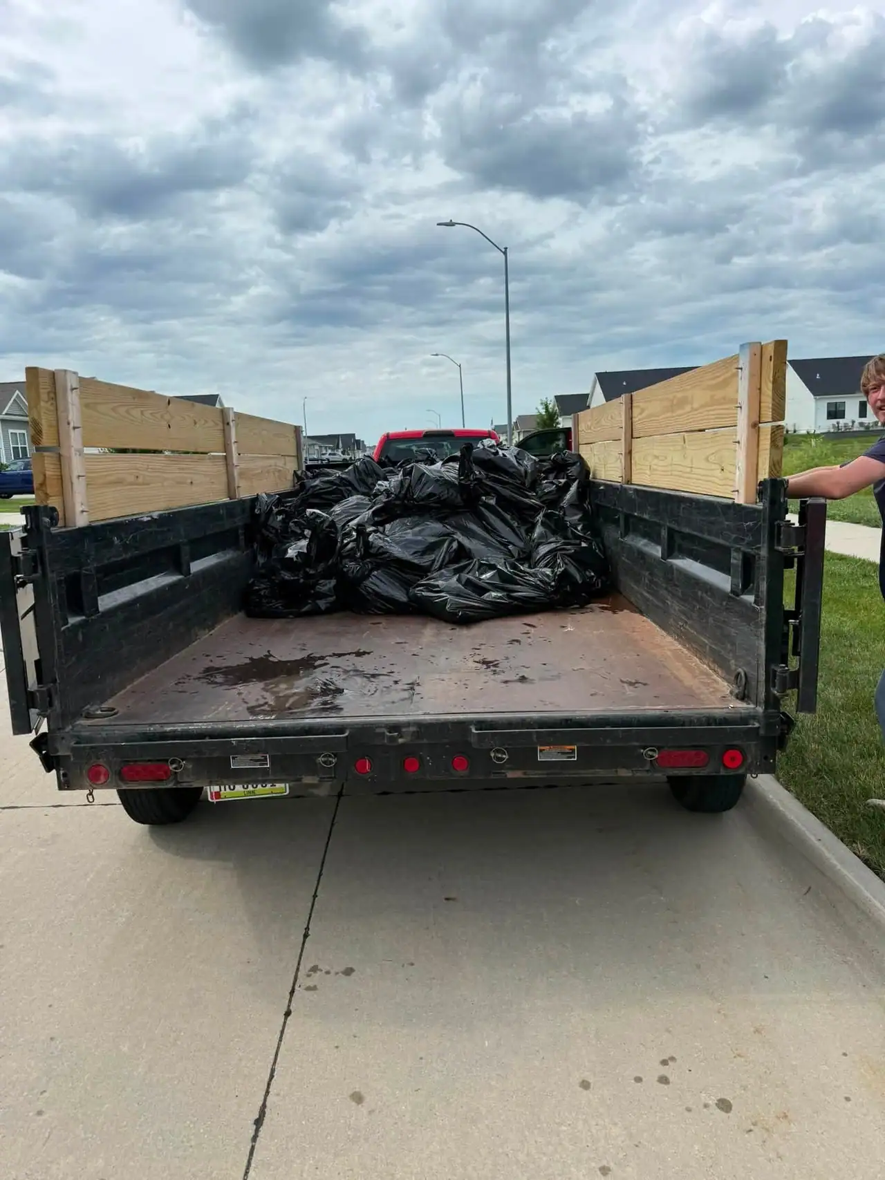 Dump trailer loaded with bags of junk cleared from a Des Moines property